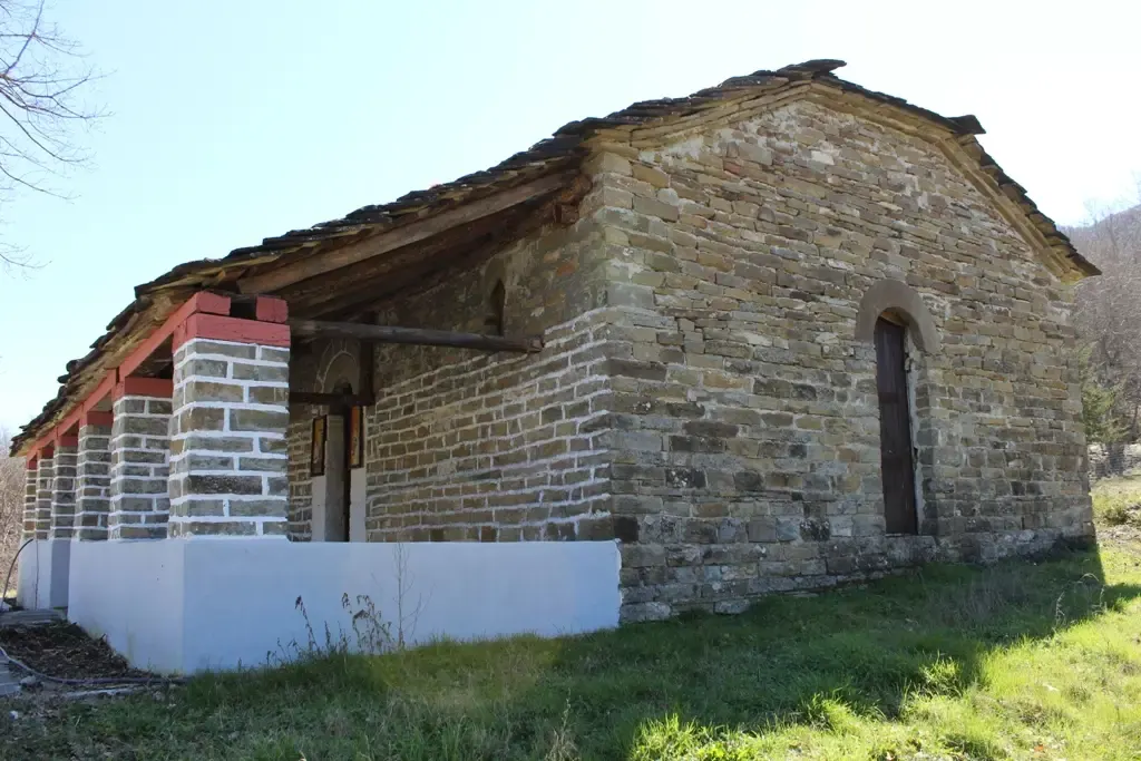 Murs de pierre et porche à piliers de l'église Sainte-Kyriaki à Grabovë par une journée ensoleillée