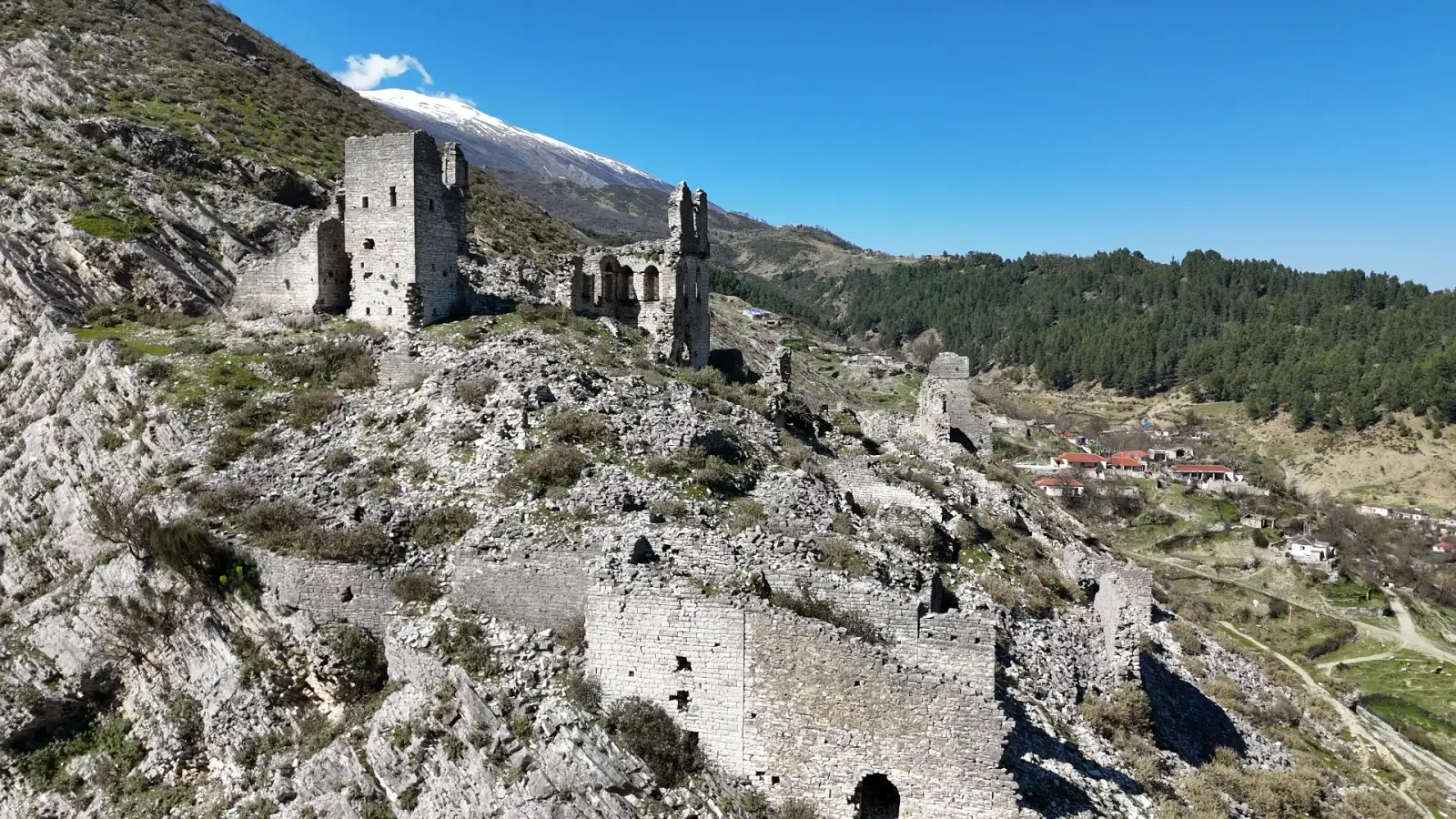 Torres y muros en ruinas de Sarajet e Ali Bej Këlcyra sobre un pueblo